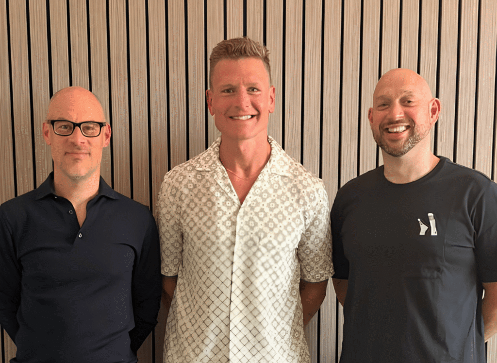 Infinity Blue Group and Rocketfuel Strategies logos side by side with an 'x' connecting them, over a photo of three men standing together, with the headline 'We've acquired a Commercial Growth Partner.'